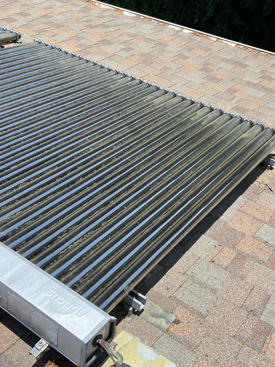 Close view of the end of a collector tube array and manifold with a flashed copper pipe penetration