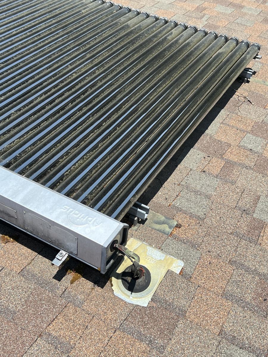 Copper pipe running from a collector manifold to a flashed roof penetration wrapped in black pipe insulation